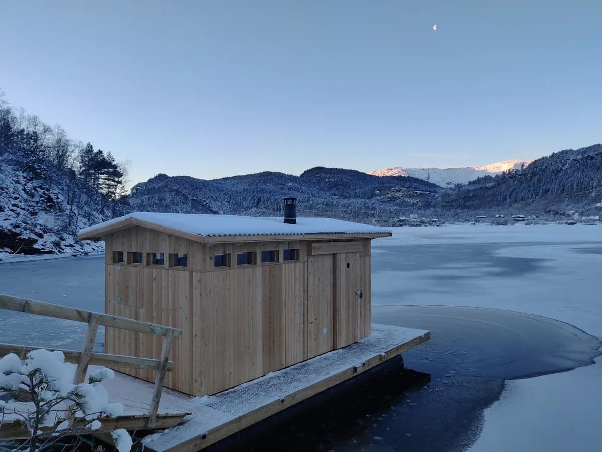 Bjørkheim Sauna i vinterlandskap ved fjorden i Årland, snødekt flytande badstu