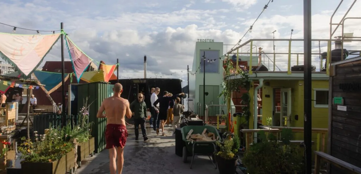 Promenaden på Sukkerbiten flytende badstulandsby i Oslo med fargerike vimpler og badstuer