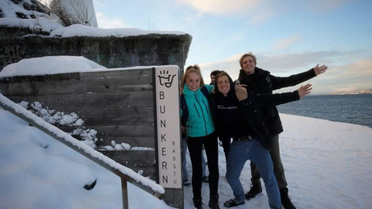 Bunker Sauna i Trondheim sett utenfra med skilt, bunker og Trondheimsfjorden i bakgrunnen